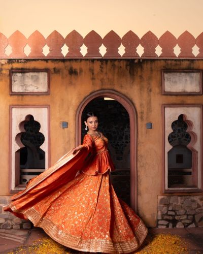 Rust orange pure cosmos tissue silk Lehenga with  heavy peplum top and dupatta