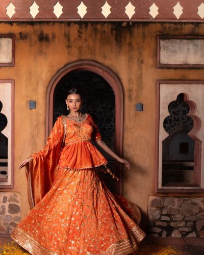 Rust orange pure cosmos tissue silk Lehenga with  heavy peplum top and dupatta